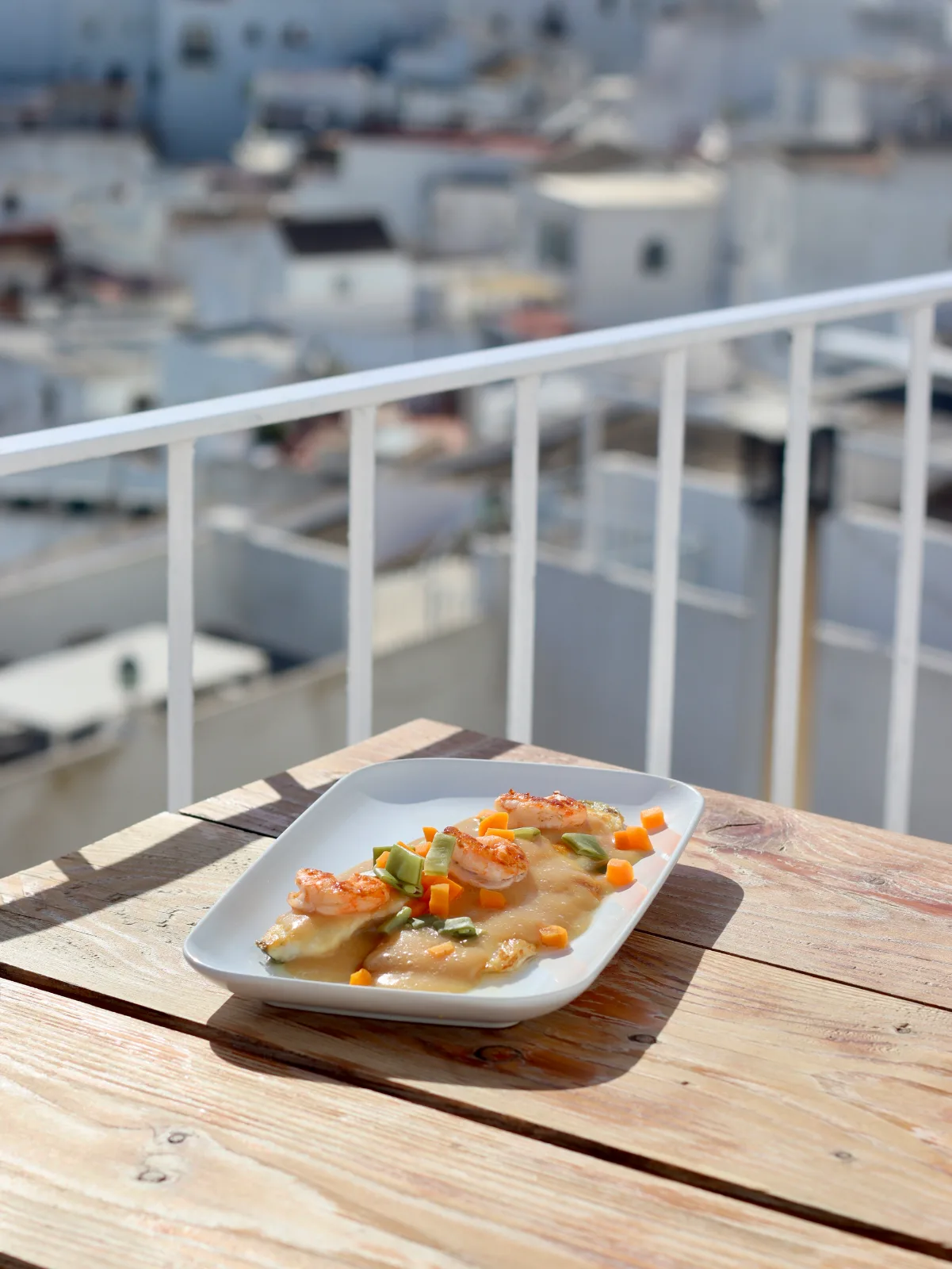 Andalusisches Gericht serviert auf der Terrasse des Restaurante La Judería de Vejer, mit Blick auf die Altstadt von Vejer de la Frontera